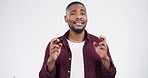 Face, fingers crossed black man in studio for hope, luck or wish, nervous or waiting for feedback on white background. Portrait, anxiety and guy model with hand emoji for news, results or competition