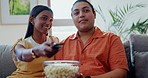 Couple, popcorn and watch movies on tv, news and cable show for media broadcast on sofa at home. Happy man, woman and people change television remote for streaming multimedia, subscription and snack 