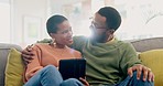 Happy couple, hug and tablet on sofa for streaming, subscription or internet search at home. Love, relax and black woman with man in living room online for social media, movie or bond in a house 