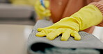 Hands, person and cloth for cleaning table in house living room for virus safety, bacteria and furniture dirt. Gloves, fabric and spray bottle closeup for liquid chemical product in desk housekeeping