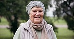 Senior person, smile and happy face in a park for a walk in retirement with outdoor wellness and gratitude. Nature, relax and elderly portrait with travel and winter vacation in a garden on holiday