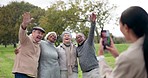 Funny, phone and photograph of senior friends at park, nature garden and bonding outdoor. Smartphone, laughing and picture of elderly group of people, wave hello and happy together on social media