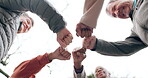 Elderly people, fist bump and fitness in team motivation or support in outdoor unity at old age home. Senior group hands together in teamwork goals, mission or exercise and workout below in nature