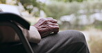 Hand, retirement and an elderly person in a wheelchair outdoor with a view of nature closeup to relax. Waiting, summer or park and a senior adult with a disability in a garden during the day