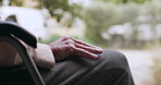 Hand, retirement and a senior person in a wheelchair outdoor with a view of nature closeup to relax. Waiting, summer or park and an elderly adult with a disability in a garden during the day