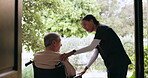 Caregiver, talking and man in a wheelchair outdoor in garden to relax with nature, conversation and nurse in retirement home. Elderly, care and worker in healthcare to support person with disability