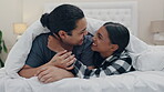 Love, kiss and a couple laughing in bed while in their home to relax in the morning on vacation or holiday. Smile happy or funny with a man and woman in the bedroom together for weekend bonding