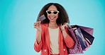 Portrait, shopping bag and woman with credit card in sunglasses isolated on a blue background mockup space in studio. Happy, gift and face of African customer with plastic money for sales in fashion