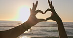 Couple, heart and hands at beach in sunset sky for love, care and romantic holiday, vacation and summer flare. Closeup, people and finger shape at sea in silhouette for support, freedom or emoji sign
