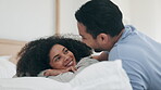 Happy couple, relax and laughing on bed in morning bonding or quality time together at home. Man and woman lying in bedroom enjoying holiday break, weekend or honeymoon vacation in happiness at house