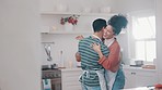 Laugh, happy and couple dance in the kitchen while cooking, bonding and having fun together. Smile, happy and young man and woman moving to music, playlist or radio and preparing dinner meal at home.