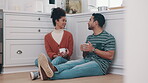 Drink, coffee and couple talking on the floor in kitchen together to relax with conversation or communication with beverage. Drinking, tea or people with hot chocolate in home on weekend or holiday