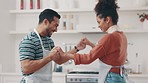 Love, smile and couple dance in the kitchen while cooking, bonding and having fun together. Happy, romance and young man and woman moving to music, playlist or radio and preparing dinner meal at home