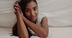 Face, smile and a sensual woman in bed, rolling around for freedom in the morning while looking playful. Portrait, happy and natural with a happy young person alone in the bedroom of her home