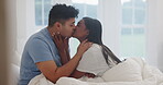 Man, woman and kiss in bedroom for love, care or intimate moment in relationship together at home. Couple, partner and kissing in bed for romance, happy morning or enjoy anniversary on valentines day