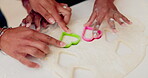 Cookies, heart and hands of mother and daughter in kitchen for cooking, breakfast or learning. Food, love and support with closeup of people and helping in family home for dessert, recipe or pastry