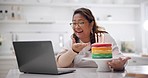 Laptop, video call and woman with birthday cake at her home for celebration, party or event. Technology, communication and happy mature female person on virtual conversation with dessert and candles.