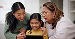 Grandmother, mother and girl on a tablet as a family playing a game in the living room of their home together. Love, education or internet with a senior woman and daughter teaching a kid online