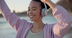 Dance, headphones and woman with music at the beach for outdoor cardio workout or training. Happy, energy and female person moving and listening to song, playlist or radio by the ocean for exercise.