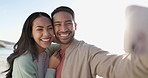 Selfie, peace sign and couple at beach, happy and bonding together on vacation. Wink, interracial man and woman smile in profile picture, memory and travel on holiday at ocean on sunset lens flare