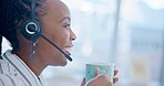 Black woman, call center and drinking coffee in relax, customer service or telemarketing at office. Calm African female person, consultant or agent enjoying hot beverage in contact us at workplace