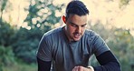 Fitness, man and runner check time in nature for exercise, workout or training goals, marathon and outdoor journey. Athlete or person with smart watch for running, lose weight challenge and focus