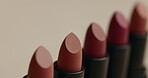 Closeup, lipstick product and makeup with advertising and beauty, cosmetics and color isolated on studio background. Ads, marketing and cosmetology, wellness and aesthetic with promo and selection