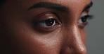 Eyes, face and skincare with a woman on a gray background in studio closeup for cosmetics. Beauty, vision and natural care with a young person looking confident with her skin or facial treatment