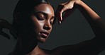 Beauty, sensual and young woman in a studio with body care, wellness and health routine. Cosmetic, movement and portrait of an Indian female model with glowing skin treatment by a black background.