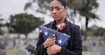 Funeral, death and rose for a woman with a flag at a cemetery in mourning at a memorial service. Sad, usa and an army wife as a widow with a flower in a graveyard feeling the pain of loss or grief