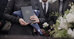 Hands, american flag and bible with a person at a funeral, grieving a loss at a graveyard. War, cemetery and death with an army wife at a memorial service to say goodbye to a fallen soldier closeup