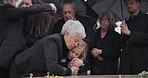 Funeral, crying family and child hug grandmother for support, mourning depression and death at emotional burial event. Dead, love and kid hugging senior woman, grandma and grief at farewell ceremony