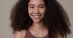 Beauty, haircare and smile with face of woman in studio for skincare, cosmetics or self care. Happy, hairstyle and natural with portrait of person on brown background for texture, health or wellness