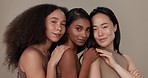 Women, group and face for skincare, beauty or cosmetics with diversity on a brown studio background. Friends or people hug in portrait together for skin care, dermatology inclusion and foundation
