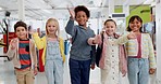 Education, diversity and children wave with friends in a classroom together for learning, growth or development. Portrait, smile and happy student kids saying hello in back to school class together