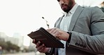 Tablet, networking and closeup of businessman in the city scroll on social media, mobile app or the internet. Digital technology, professional and male lawyer browsing on website in urban town road.