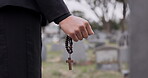 Rosary, death or hand cemetery for funeral. spiritual service or grave visit to repsect the Christian religion. Mourning, goodbye or closeup of person outside in graveyard for grief, loss or farewell