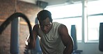 Gym, battle rope and black man with fitness, energy and health with endurance, muscle and bodybuilder. African person, athlete or guy with workout, training and cardio with wellness, energy and power