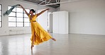 Dress, dancing and a woman for performance in a creative art studio with energy and passion. African contemporary dancer practice for theater, sports and freedom with balance, textile and talent