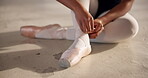 Ballet, shoes and hand of dancer tie ribbon in dance studio, art academy or creative school for practice and training. Student, artist and person sitting on ground and getting ready for performance