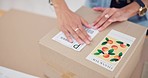 Online order, delivery label and woman hand with small business sticker for cardboard box. Stock, startup process and sales of ecommerce and boutique at home of a entrepreneur with courier package