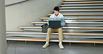 Laptop, homework and student man on a staircase at university for education, learning or study. Computer, college or school with a person online for research or assignment during academic scholarship