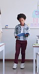 Child, boy reading and classroom with kid speaker, book and education at a school. Students, learning and notebook with development, knowledge and study work with story discussion of youth assessment