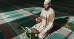 Islam, praying and man in mosque with Quran, mindfulness and gratitude in faith reading. Worship, religion and Muslim Imam in holy temple for praise with book, spiritual teaching and peace meditation