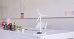 Renewable energy, wind turbine and classroom at school, innovation and windmill model on table for sustainability. Eco friendly, environment and stationary on desk for student learning and education