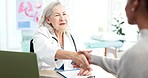 Doctor, patient and handshake for healthcare consultation with advice, welcome or thank you. Medical worker and woman at hospital for conversation and shaking hands for visit and trust for wellness
