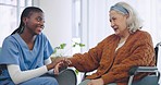 Senior woman, wheelchair and nurse with holding hands, talk and listen for help, support and care in retirement. Caregiver, nursing home and elderly person with disability, happy and rehabilitation