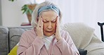 Headache, stress and retirement with a senior woman on a sofa in the living room of her home alone. Mental health, burnout and pain with an elderly person rubbing her head while feeling tired