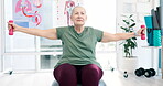 Mature woman, barbell and exercise in physiotherapy on ball for muscle at hospital. Physical therapy, weights and person training for body health, fitness or rehabilitation workout, wellness or power