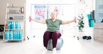 Mature woman, dumbbell and exercise ball in physiotherapy for muscle at hospital. Physical therapy, weights and person training for body health, fitness or rehabilitation workout, wellness or power